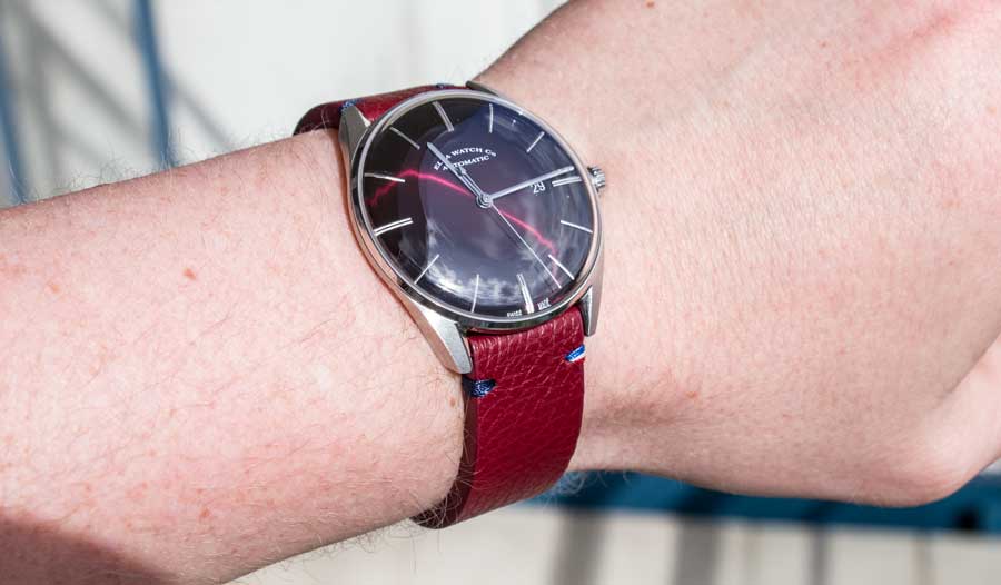 Le bracelet en cuir bordeaux Avel sur la montre Elka, assorti au cadran rouge.